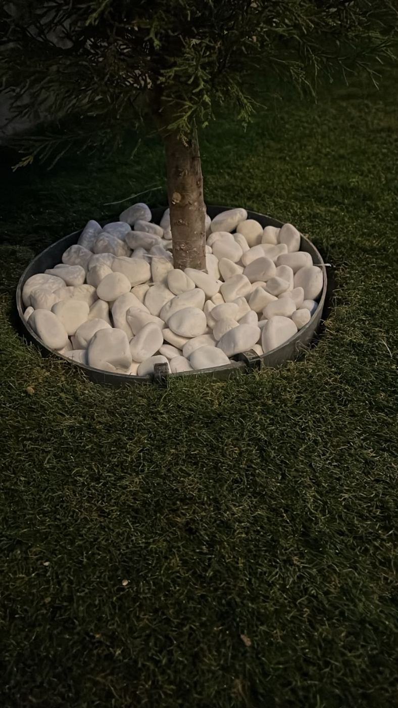 Ağaç dibinde dairesel separatör ve beyaz dere taşı